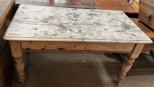 A Victorian pine kitchen table with a rectangular planked top on four turned legs,