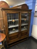 A 1920's oak barley twist and leaded glazed door display cabinet