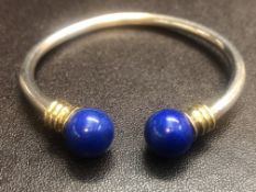 Silver child's bangle with yellow metal collars &