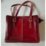 Liberty- A vintage burgundy leather shoulder bag having 2 handles and gold tone hardware, 2 internal