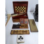 A Victorian mahogany games compendium with folding chessboard and turned wooden pieces, bone and