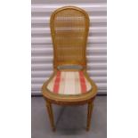 A gilded wooden chair with rattan back and upholstered seat on four fluted tapering cylindrical