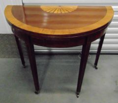 An Edwardian demi-lune mahogany and satinwood inlaid games table on tapering rectangular legs with