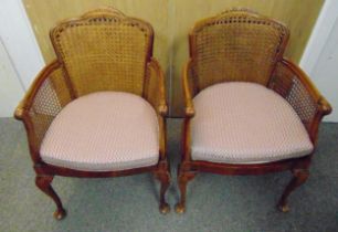 A pair of early 20th century mahogany bergere occasional chairs