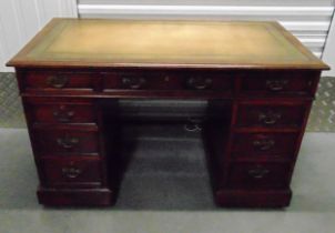 An Edwardian rectangular mahogany pedestal desk with nine drawers, brass swing handles and an inlaid