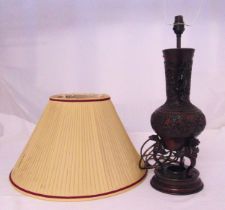 An oriental bronze lamp stand decorated with stylised flowers, leaves and dragons, supported by