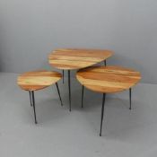 A contemporary nest of three triangular occasional tables, with acacia tops on tapered metal legs.