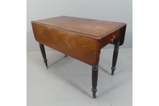 A Victorian mahogany drop-leaf table, with end frieze drawer and raised on fluted legs with brass - Image 1 of 2