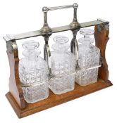 A late Victorian electroplate mounted oak three bottle tantalus