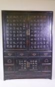 A Chinese lacquered cabinet, decorated with carved and raised painted inscriptions