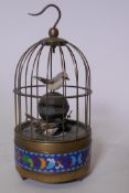 A brass bird cage automaton alarm clock with cloisonne border, 21cm high