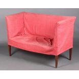 An Edwardian Georgian style sofa upholstered in white material with pink loose cover, raised on