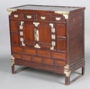 A Chinese hardwood cabinet with "silver" metal mounts fitted 4 short drawers above a cupboard