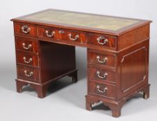A Victorian style kneehole pedestal desk with green leather writing surface fitted 1 long and 8