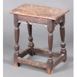 An 18th Century rectangular oak joined stool with carved apron, raised on turned and block