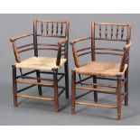 William Morris, a pair of ebonised elm Sussex armchairs with spindle backs and woven rush seats,