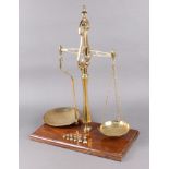 Librasco, a pair of 19th Century 2lb brass scales on a mahogany base, together with 6 brass bell
