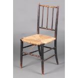 William Morris, an ebonised elm Sussex stick and rail back chair with woven rush seat, raised on