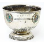 An Arts & Crafts silver pedestal bowl with hammered decoration and enamelled roundels attributed