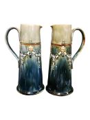 A PAIR OF EARLY 20TH CENTURY ROYAL DOULTON LAMBETH JUG EWERS