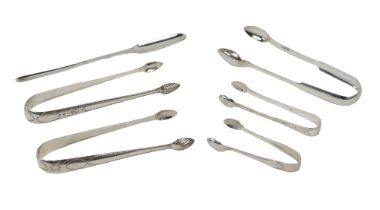 Silverware:  A collection of Irish and English silver Sugar Tongs, of plain and bright cut design