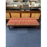 Low Upholstered Bench raised on legs with castors. Covered in tapestry fabric. Measures 16'' high,