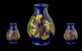 Moorcroft Hand Painted Tube lined Globular Shaped Vase ' Hibiscus' Design on Blue Ground. Height 5.5