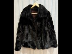 Ladies Astraka Black Fur Jacket, fully lined in sateen fabric, hook and eye fastening, slit pockets.