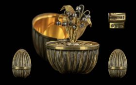An Elizabeth II Franklin Mint Silver Gilt Surprise Egg, containing a detachable lily brooch, in a