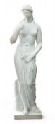 After the Antique. A large 19th century reconstituted marble figure of Venus, standing beside a tree
