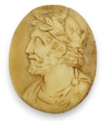 An 18th century unmounted oval horn cameo, carved with the head of Caesar to dexter, 49mm. Condition