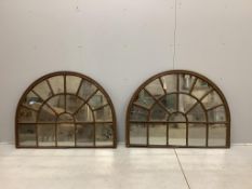 A pair of architectural cast iron window panel wall mirrors of domed form, width 136cm, height