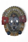 African art - a Liberian/Ivory Coast Dan mask with shell mounts together with another, largest
