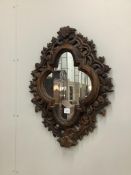 An 18th century style shaped oval carved pine wall mirror, width 61cm, height 79cm. Condition -
