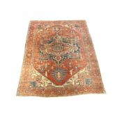 An antique Heriz carpet with central medallion and foliate motifs on a brick red ground, 358 x 297cm