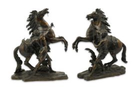 After Guillaume Coustou (1677-1746), a pair of bronze Marli horse groups, each with a groom