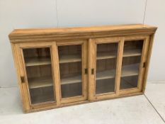 An early 20th century oak bookcase enclosed by sliding doors, width 164cm, depth 36cm, height