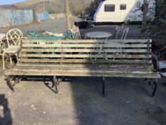 A wrought iron slatted wood garden bench, width 243cm, height 84cm. Condition - poor