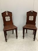 A pair of Victorian mahogany hall chairs with tile inset backs, width 43cm, depth 37cm, height 88cm.