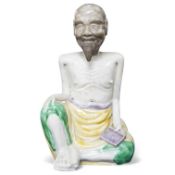 An 18th century Chinese polychrome glazed porcelain seated figure of a luohan, 14cm high