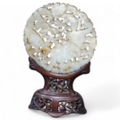 A Chinese pierced jade disc, on stand, 15cm high. Condition - good