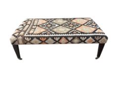 A large rectangular coffee table / footstool with polychrome Kilim upholstered top, width 143cm, dep