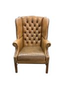 A George III style buttoned tan leather wing armchair, width 74cm, depth 74cm, depth 64cm, height 10
