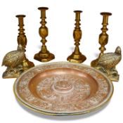 A group of copper and brassware to include candlesticks and an alms dish, 45cm in diameter