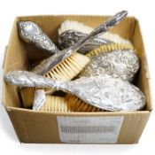 An Edwardian repousse silver mounted six piece dressing table mirror, brush and comb set, by Henry M