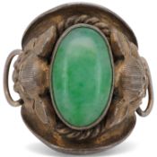 A 20th century Chinese white metal and single stone cabochon jade set ring, the shoulders