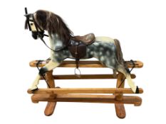 A modern dapple grey rocking horse, unsigned, on a pine base, height to the top of the head 109cm,