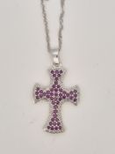A modern 9ct white gold, ruby and diamond chip cluster set cross pendant, overall 37mm, on a 9ct