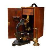 An early 20th century pine and plywood cased microscope by C.Baker, London, containing an integral