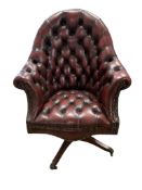 A reproduction buttoned burgundy leather swivel desk chair, width 80cm, depth 70cm, height 110cm